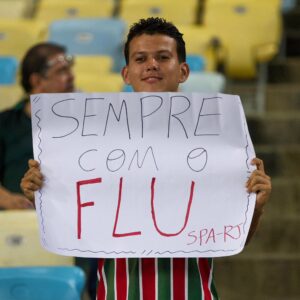 Rapaz com cartaz em apoio ao Flu