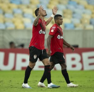 Luiz Fernando comemora seu gol com os braços levantados.