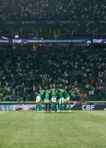 Jogadores do Palmeiras se abraçam no meio-campo.